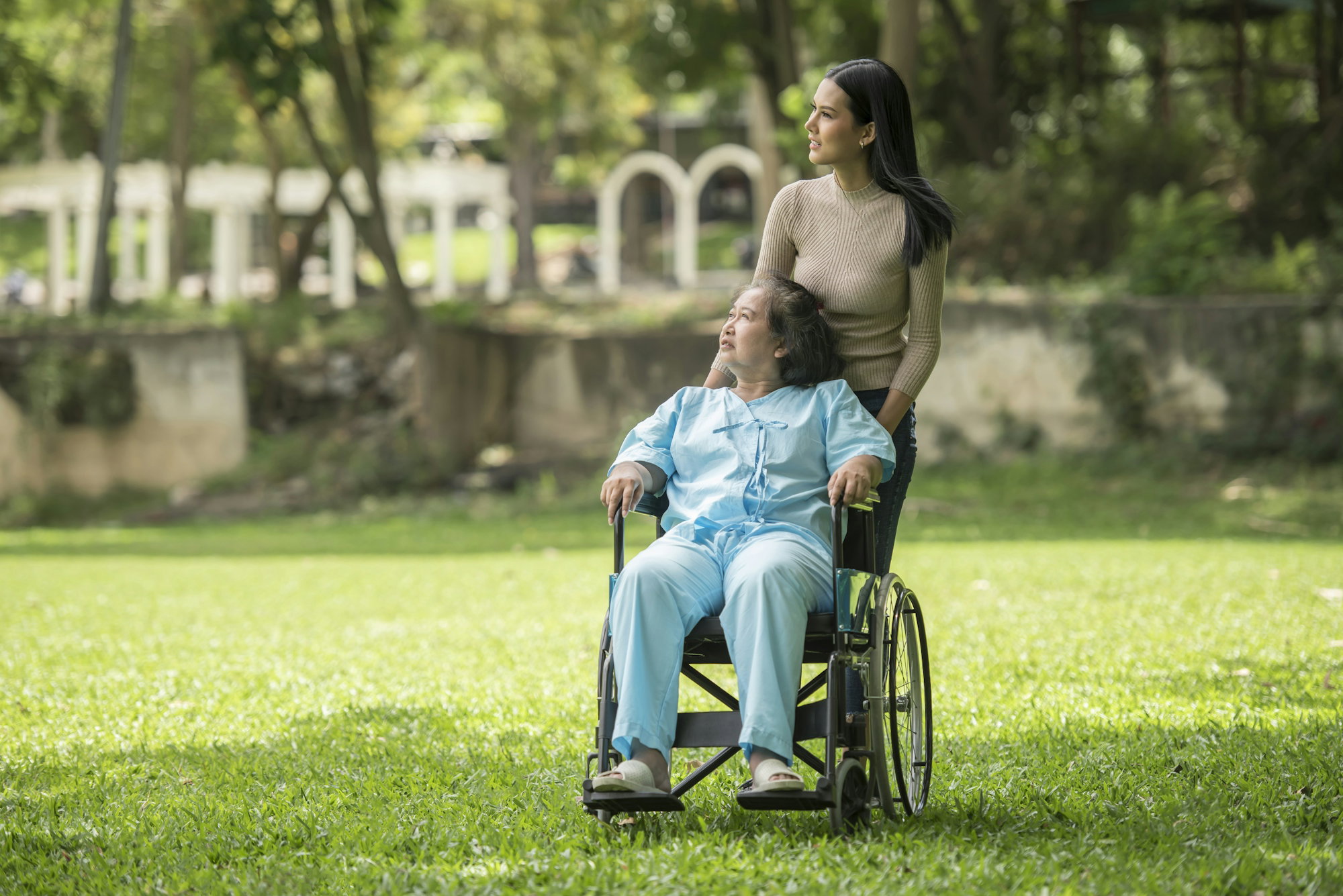 a-woman-in-a-wheelchair-standing-next-to-a-man-in-a-park.jpg A woman in a wheelchair standing next to a man in a park